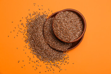 Bowls with flax seeds on color background