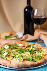 Pizza with mozzarella, salmon slices, fresh arugula. Served with baked cheese camembert and red wine. Italian cuisine
