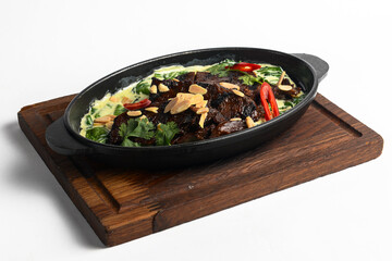 Meat with vegetables served with sauce in a pot over white background. Rustic style dinner