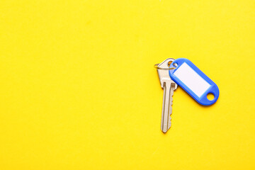 Plastic tag with key on color background