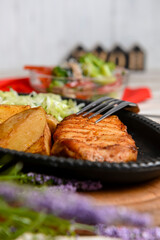 Grilled Chicken Steak with fried potatoes in rural style and coleslaw salad served in a tray over white background.