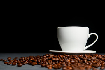 Warm cup of coffee with coffee beans over black background. Coffee time, copy space web design banner.