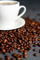 Warm cup of coffee with coffee beans over black background. Coffee time, copy space web design banner.