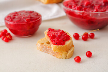 Tasty sandwiches with red currant jam on light background