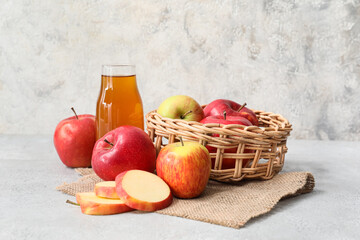 Bottle of apple juice and fresh fruits on light background