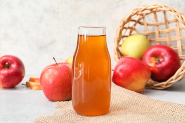 Bottle of apple juice on light background