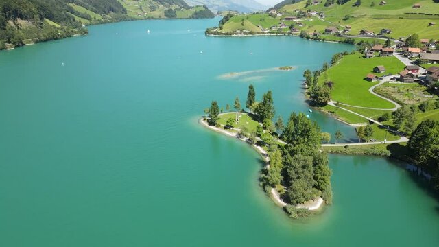 Cinematic circular aerial shot of Lungern Lake and Swiss Alps, Switzerland