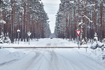 Car on snowy road in forest in winter