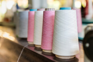 Receding line of alternating reels of pink and white cashmere