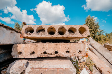  Used concrete slabs lay on top of each other near an industrial area on a bright sunny day. High quality photo
