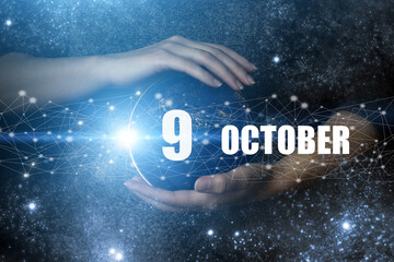 October 9th. Day 9 of month, Calendar date. Human holding in hands earth globe planet with calendar...
