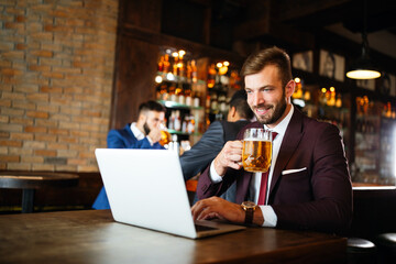 Portrait of a successful business man sitting at the cafe working on a laptop.