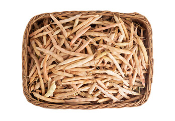 Dry bean pods in a wicker basket on a white background, isolate, close-up