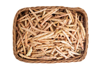 Obraz premium Dry bean pods in a wicker basket on a white background, isolate, close-up