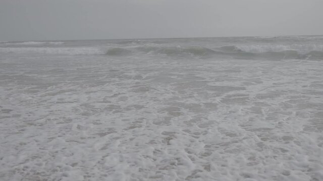 s log footage. white sand beach. waves crashing to the shore. White ocean see water. cloudy climate. nature landscape
