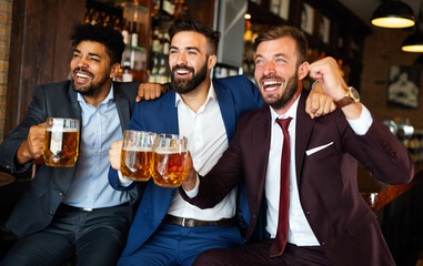 Business men in pub cheering for a sporting event