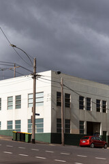 White building and red car on dark sky.