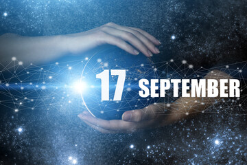September 17th. Day 17 of month, Calendar date. Human holding in hands earth globe planet with...
