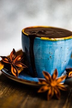 Close-up of a cup of fresh hot chocolate with star anise and cinnamon