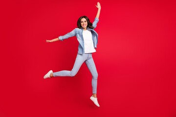 Full length body size view of attractive carefree cheerful girl jumping walking having fun isolated over vibrant red color background
