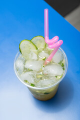 Cocktail with cucumber, lime and ice on the bar