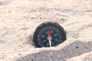 Classic navigation compass on beach as symbol of tourism with compass, travel with compass and outdoor activities with compass