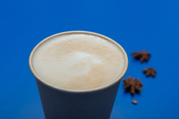 delicious cappuccino with milk on a blue background. close-up