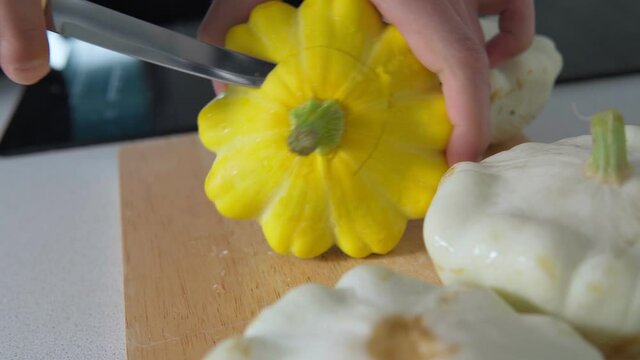 Cooking food at home in the kitchen cuts vegetables into patissons. A man prepares food