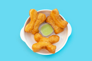 Deep-fried dough sticks or chinese bread sticks on blue background.