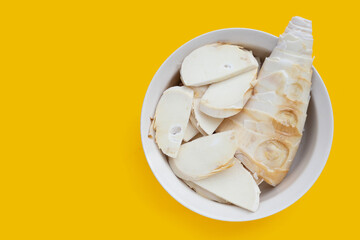 Bamboo shoots in bowl on yellow background