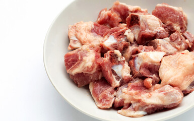 Raw pork ribs in white plate on white background.