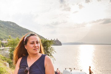 Fototapeta na wymiar Portrait of woman at sunset on the Danube river shore.