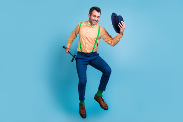 Profile photo of cheerful guy jump hold cane take off hat wear suspenders shirt bow tie isolated...