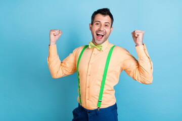Fototapeta premium Photo of hooray brunet man hands fists yell wear peach shirt isolated on blue color background