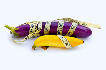 Banana with long purple eggplant wrapped in measuring tape on white background.