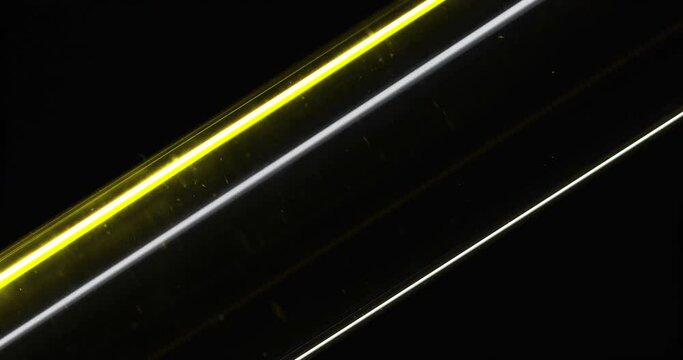 Macro shot. Oil in a test tube. Dark background. Concept. Parallel lines. Oil flowing through a glass tube. Energy. Motor fuel. Essential cosmetic extract. Oil filtration