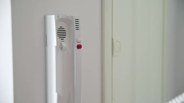 Woman take intercom handset and push button to open door lock