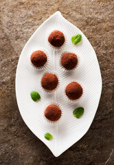 Handmade chocolate candies truffles on a plate, top view