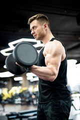 Fototapeta na wymiar Muscular athletic man training hard in gym. Handsome strong bodybuilder doing exercise.