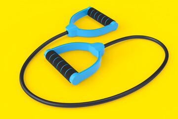 Hand expander or resistance band with rubber handle isolated on yellow.