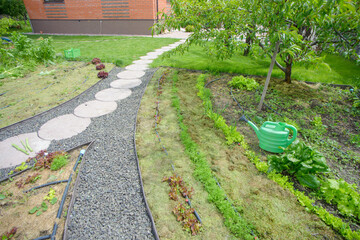 gardener mulching flower bed with pine tree bark mulch