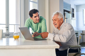 Sohn hilft seinem Vater am Laptop Computer zu Hause