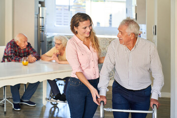 Pflegekraft hilft Senior beim laufen lernen mit Rollator