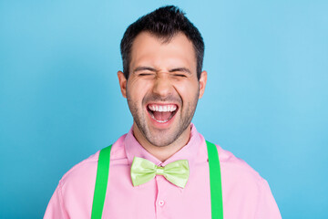 Photo of funny excited crazy guy wear green suspenders pink shirt bow tie isolated blue color background