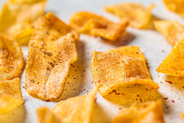 Spicy banana chips on gray background. Indian food concept.