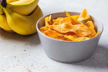 Spicy banana chips on gray background. Indian food concept.