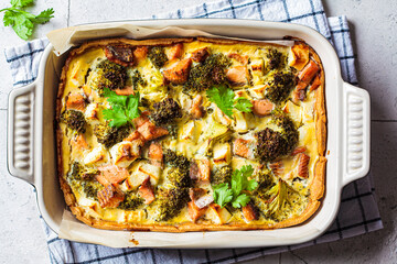 Quiche pie with salmon and broccoli in baking dish.