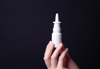 female hand holding nose spray