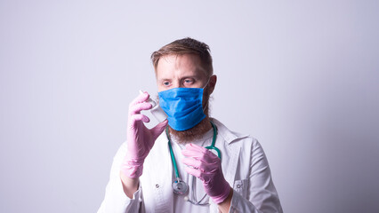 Fototapeta na wymiar a young doctor in a mask holds a remedy for the common cold