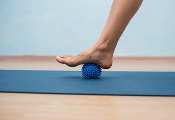 close-up of a person's leg doing exercises with a massage ball with needles